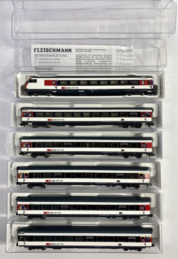 Fleischmann, Écartement N, 1/160ème, Rame de la SBB CFF FFS se composant de 6 wagons dont le control car,  4 wagons voyageurs 2ème classes et 2 wagons voyageurs 1ère classes. Crème et blanc/bleu nuit à toit bleu foncé. Réf 890307, 890308, 890205, 890204, 890184 (K). NB