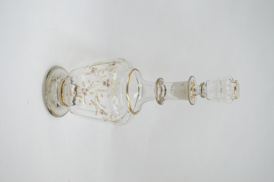 Carafe en verre soufflé émaillé d'un décor de gerbe de fleurs dans le goût de Legras. Accident à la base du bouchon. Travail Art Nouveau du début du XXe siècle. H. : 34,5 cm.