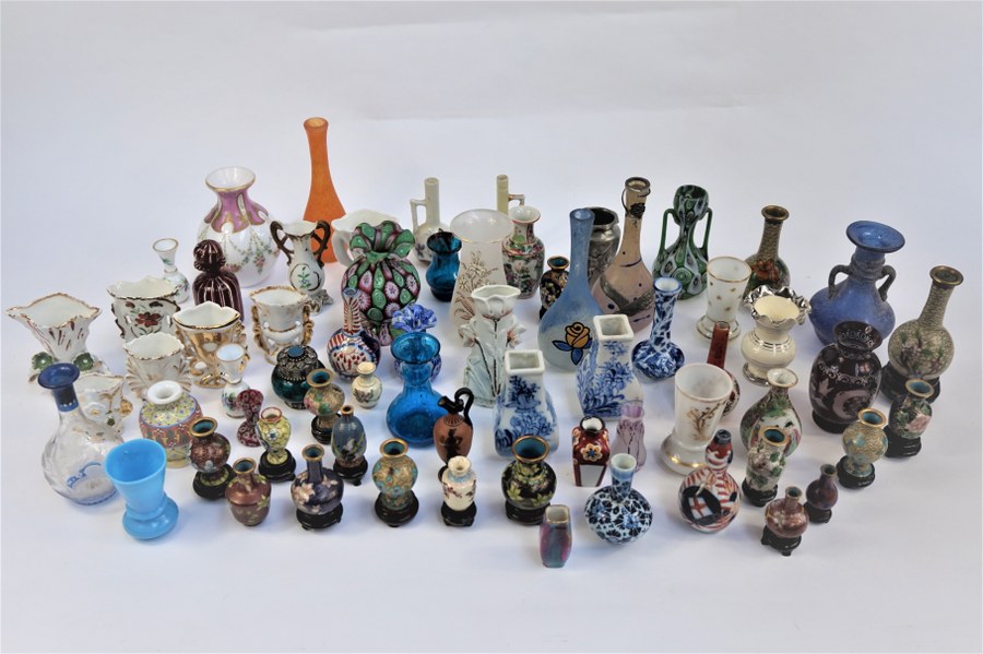 Lot d'une soixantaine de petits vases de vitrine en verre soufflé, verre émaillé, porcelaine, céramique, métal cloisonné, dont deux signés Quènvil, petits vases chinois, l'un dans le goût de DAUM. XIX-XXe siècle.