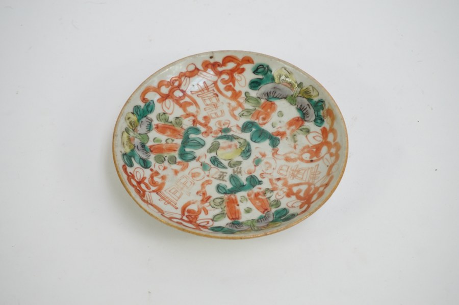 Petite assiette en porcelaine chinoise à décor de glaçure rouge et vert. Fin XVIIIe - Début XIXe siècle. Diam. : 13,2 cm. Fêle sur le marly.