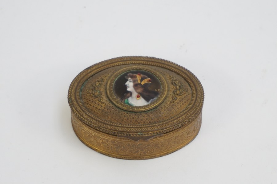 Petite boîte ovale en métal doré à profil d'élégante en émail signé S.B. Fin du XIXe siècle. 3 x 9,5 x 8 cm.