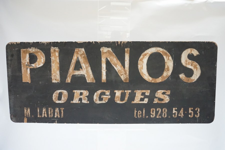 Panneau publicitaire en bois pour pianos et orgues. XXe siècle. 63 x 161cm.