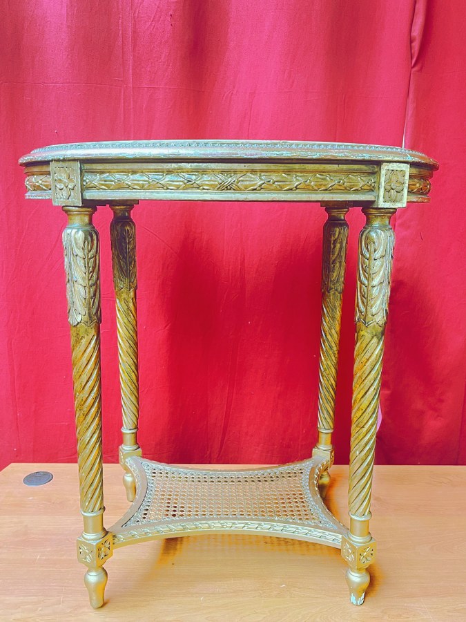 Guéridon à décor Néoclassique de style Louis XVI en bois doré. Dessus de marbre accidenté.