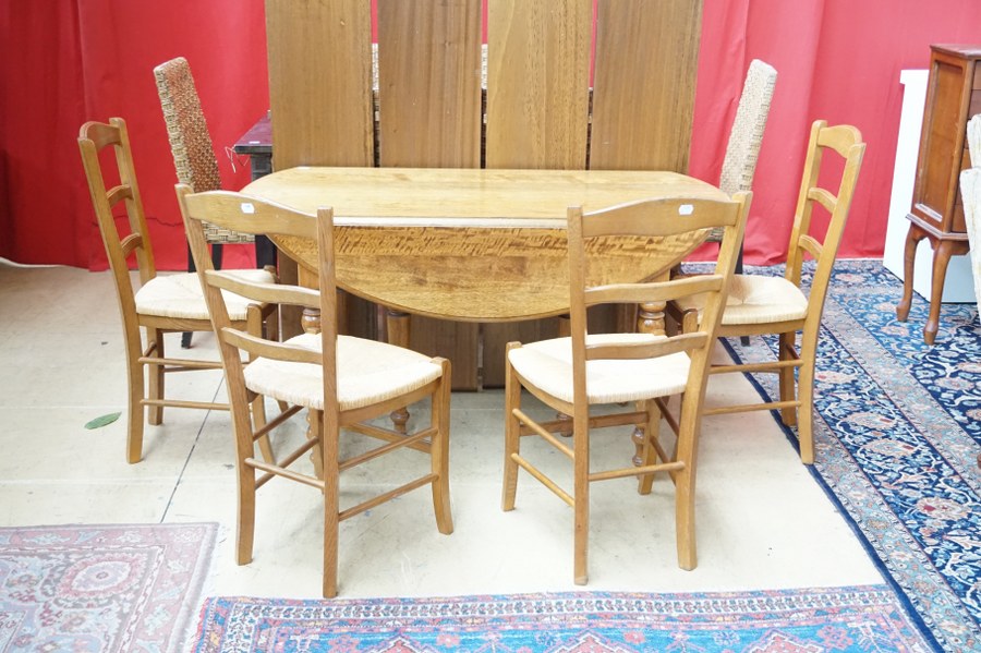 Table avec 4 allonges et 4 chaises paillées.
