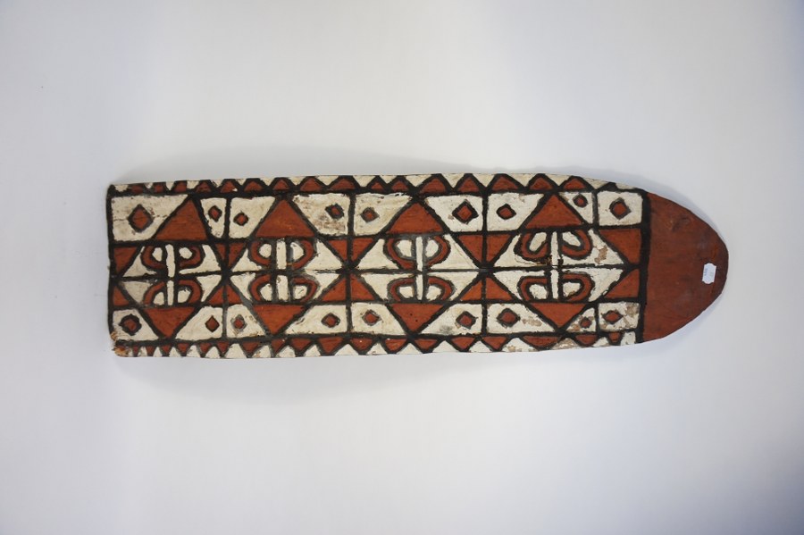 Bouclier cérémoniel ASMAT à beau décor géométrique de triangles. Bois sculpté polychrome, fibres végétales. XXe siècle. Indonésie (Irian).